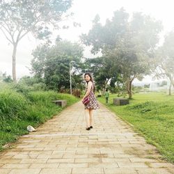 Full length of woman standing on footpath