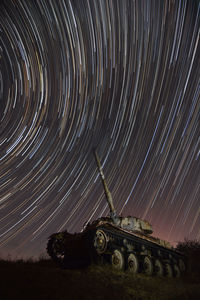 Firework display on field against sky at night