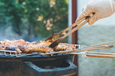 Close-up of person hand on barbecue grill