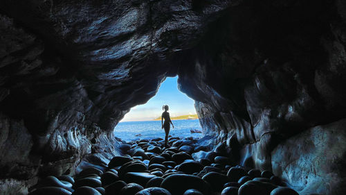 People standing on rock in sea