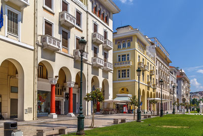 Residential buildings by street against sky