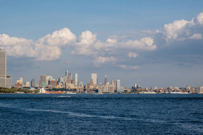 Sea by buildings against sky in city