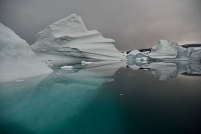 Scenic view of iceberg shapes and reflectins in mirror-like sea in greenland scoresby sound