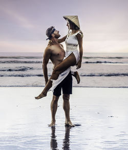 Woman standing on beach against sea
