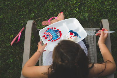 High angle view of girl eating cake in tray