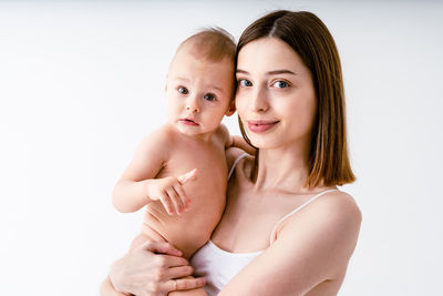Portrait of young woman against white background