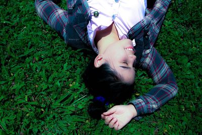 High angle view of smiling carefree woman lying on field