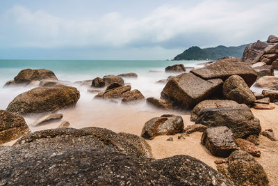 Rocks on beach against sky