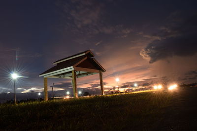 Illuminated lights on field against sky at night