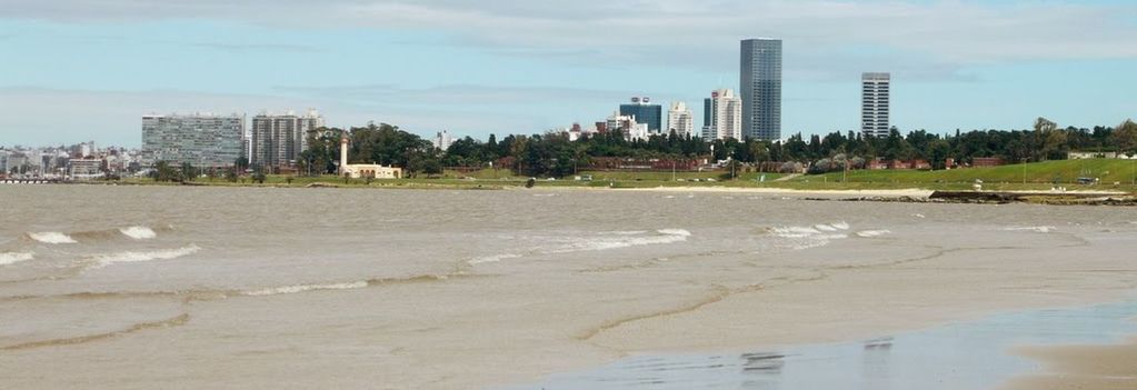 PANORAMIC VIEW OF BEACH BY CITY AGAINST SKY