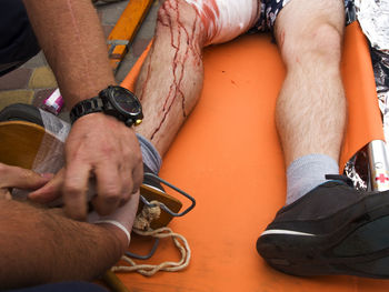 Close up of red cross workers providing first aid to injured man on stretcher