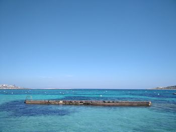 Scenic view of sea against clear blue sky