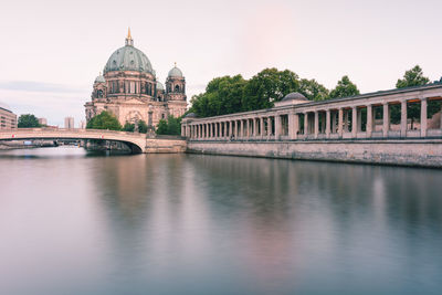 Arch bridge over river against buildings