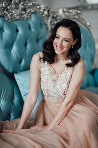 Young woman smiling while sitting on sofa