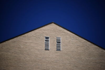 Low angle view of building against clear blue sky