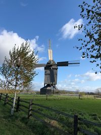 Traditional windmill on field against sky