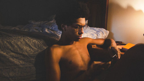 Young man lying on bed at home