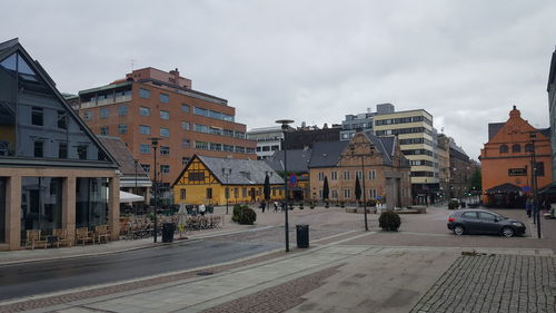 Vehicles on road against buildings in city