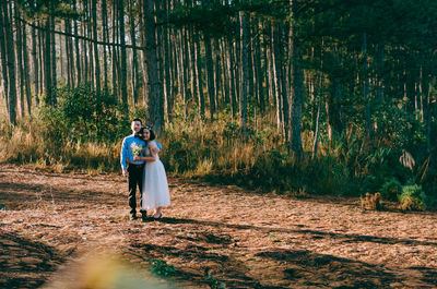 Rear view of man and woman in forest