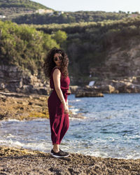 Full length portrait of woman standing by sea