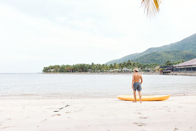 Rear view of woman in boat in sea against sky