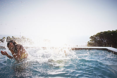 Water splashing in sea against clear sky