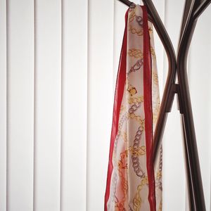 Silk scarf hanging on coat hook against blinds