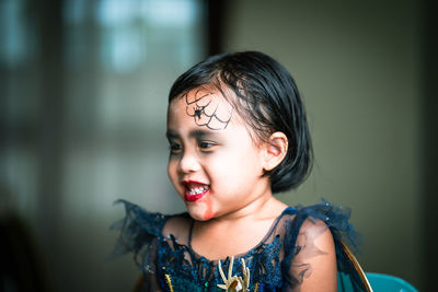 Mother painting daughters face. halloween party.
