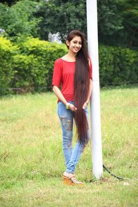 Portrait of smiling young woman standing in park