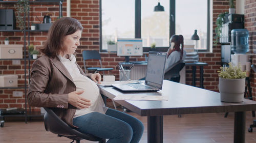 Pregnant businesswoman working at office