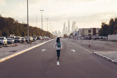 Rear view of woman walking on road in city
