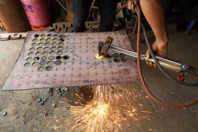 Low angle view of man working on metal