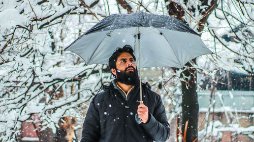 Young man standing on wet snow during winter