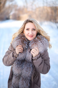 Portrait of smiling woman with snow during winter