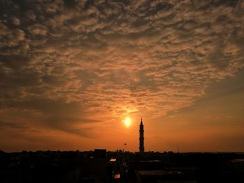Silhouette buildings against sky during sunset