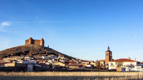 Houses in town against clear blue sky