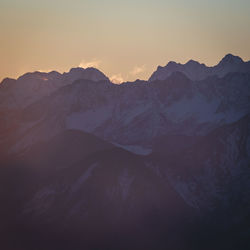 Scenic view of snowcapped mountains against sky during sunset