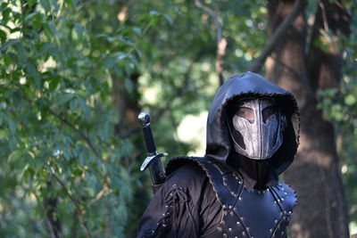 Man wearing costume against trees