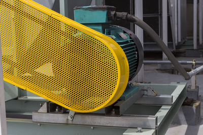 Close-up of yellow machine part in factory