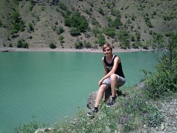 Portrait of woman sitting at lakeshore