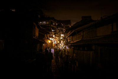 People walking on illuminated city at night