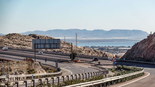 Bridge over sea by city against clear sky