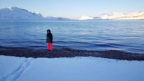 Woman on snow covered mountain against sky