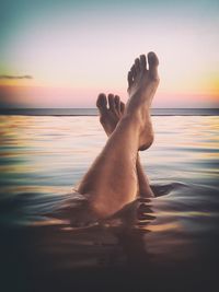 Low section of man relaxing in sea