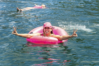 Woman in a bikini in the sea water with a buoy. 