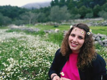 Portrait of smiling young woman standing on field