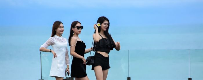 Women standing against blue sky