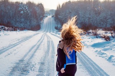 Woman on snow covered road during winter