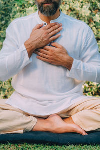 Reiki spiritual self-treatment healing session. man holding hands above the heart chakra.