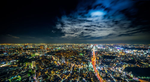 Aerial view of illuminated cityscape against sky at night